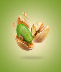 Cracked pistachios close-up on a green background