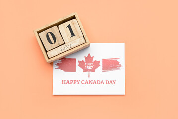Wooden cube calendar with date JULY 1 and paper card with text HAPPY CANADA DAY on color background