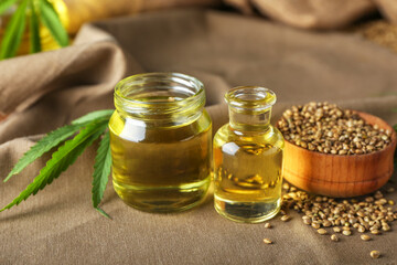 Bottles of hemp oil and seeds on table