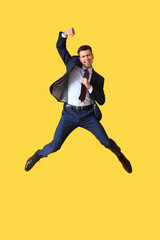 Fototapeta na wymiar Jumping young businessman on yellow background