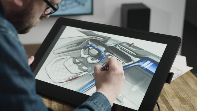 An industrial designer develops a new car interior concept. A man uses a professional graphics tablet to sketch.