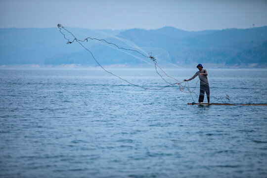 A man crawling fish in  Jati Luhur Dam, Purwakarta, West Java, Indonesia. 