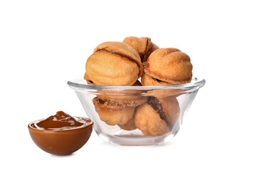 Bowl of tasty walnut shaped cookies with boiled condensed milk on white background