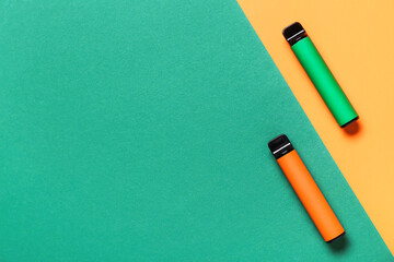 Modern disposable electronic cigarettes on color background