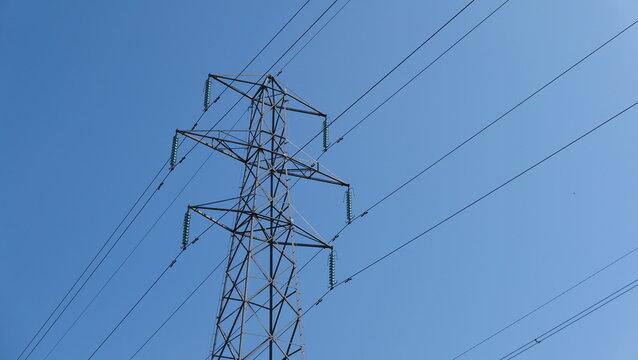 View of electricity pylon against deep blue sky with copy space