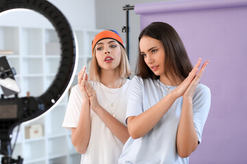 Young female bloggers recording video in studio