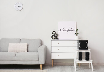 Stylish interior of living room with sofa, chest of drawers and acoustic system