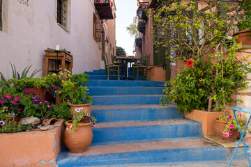 Obraz na płótnie Canvas Small narrow street with blue stairs in Old Town of Rethymnon, Crete island, Greece