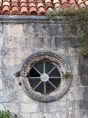 Fototapeta na wymiar Piękne stare okrągłe okno w murze na Starówce