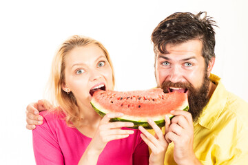 Young couple eating watermelon. Funny young couple holding piece of watermelon.