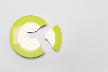 Broken ceramic plate on light background