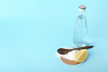 Bottle of water, baking soda and lemon slice on color background