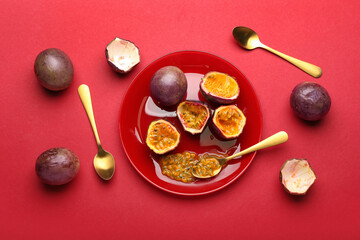 Plate with delicious cut  passion fruits on red background