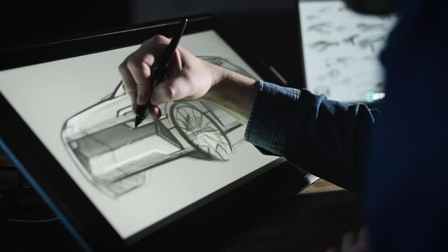 An industrial designer develops a new car concept. A man uses a professional graphics tablet to sketch. Work