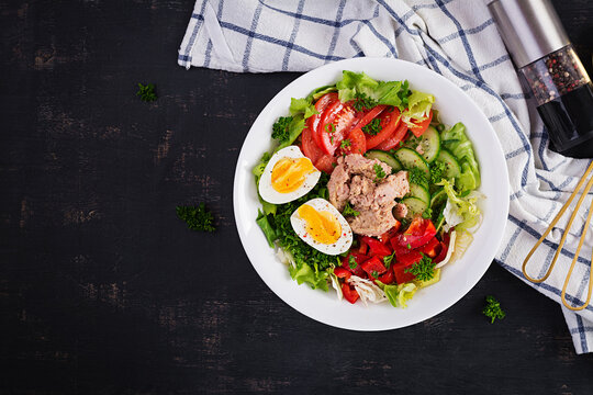 Tuna fish salad with lettuce, tomatoes, cucumber, boiled egg and sweet pepper. Healthy food. French cuisine. Top view, copy space, flat lay