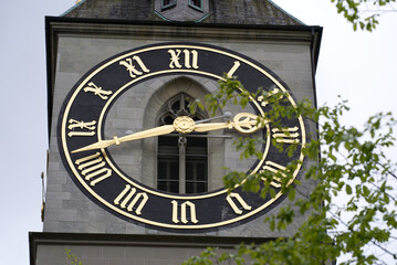 Clock tower of protestant church St. Peter with largest church clock face at the old town of Zürich on a rainy spring day, focus on background. Photo taken April 24th, 2022, Zurich, Switzerland.