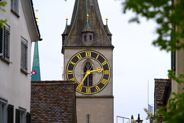 Fototapeta na wymiar Clock tower of protestant church St. Peter with largest church clock face at the old town of Zürich on a rainy spring day, focus on background. Photo taken April 24th, 2022, Zurich, Switzerland.