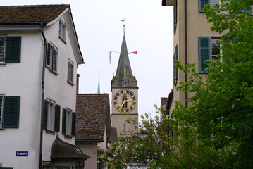 Fototapeta na wymiar Clock tower of protestant church St. Peter with largest church clock face at the old town of Zürich on a rainy spring day, focus on background. Photo taken April 24th, 2022, Zurich, Switzerland.
