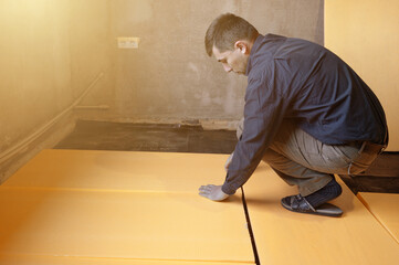 Installation of expanded polystyrene for floor insulation.