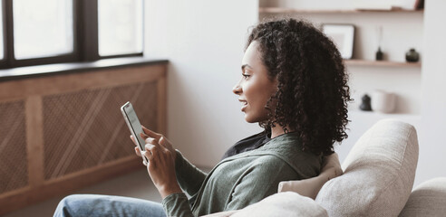 Young woman using smartphone at home panoramic banner. Student girl texting on mobile phone in her...