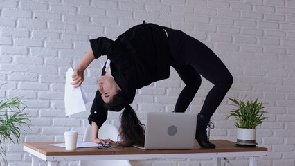 An employee of the office right on the desktop performed a complex exercise - stood on the bridge....