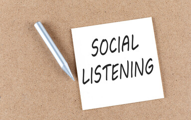 SOCIAL LISTENING text on sticky note on a cork board with pencil ,