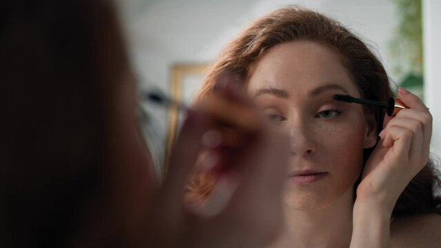 Caucasian woman applying eyelash in the mirror reflection. Shot with RED helium camera in 4K.  