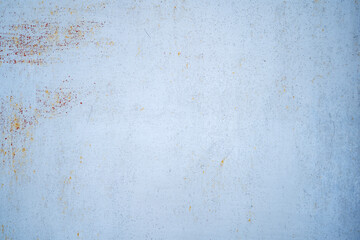 Light blue paint background on metal with a fine element of worn rust. 