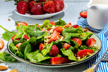 Strawberry, spinach and nuts salad. Healthy diet spring summer salad with farm spinach leaves, chopped almond and organic strawberry slices, copy space