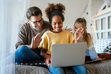 Multiethnic happy children and father studying at home for online school
