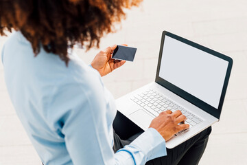 Businesswoman holding credit card using laptop for online shopping