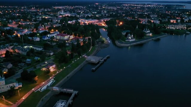 Picturesque aerial view of illuminated townscape of Uglich overlooking Kremlin cathedrals on banks of Volga River on summer twilight, Yaroslavl region, Russia. High quality 4k footage