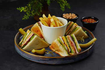 Delicious club sandwiches and crusty french fries on tray