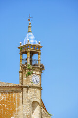 Picturesque clock tower against blue sky with stork nests. Saint Martin church, Trujillo,...