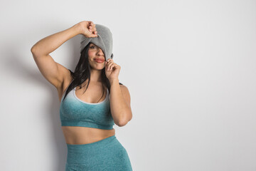 Ethnic woman in sportswear pulling hat over face