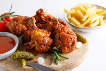 Homemade wood smoked chicken legs with french fries and chili sauce on the side.