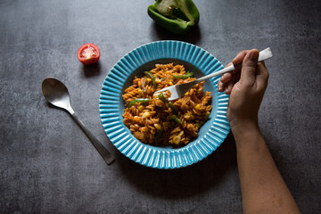 Hand of a woman holding a fork about to eat with use of selective focus 