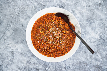 vegan lentil and couscous ragu with herbs and dukkah as topping, healthy plant-based food