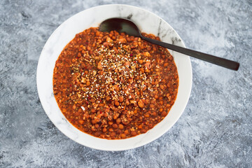 vegan lentil and couscous ragu with herbs and dukkah as topping, healthy plant-based food