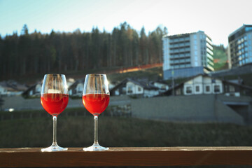 Glasses of wine on wooden balcony in ski resort