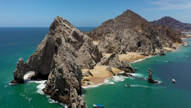 Drone shot of El Arco and Playa del Amor with boats in the ocean in Cabo San Lucas Mexico