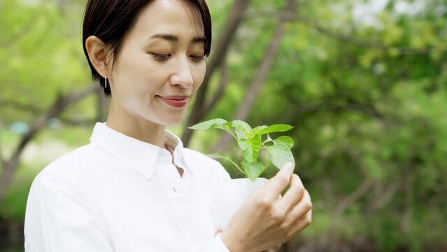 植物を持つ女性　環境保護イメージ