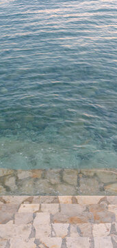 Topview shoreline Mediterranean Sea with bricks and stone. 
