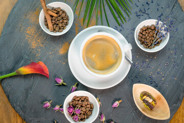 Selection of cinnamon and rose coffee beans with coffee cup in the middle