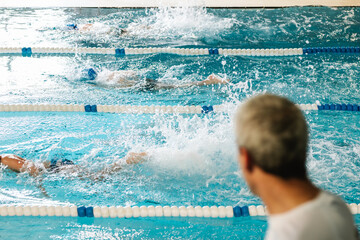 unrecognizable swimming coach coaching his students