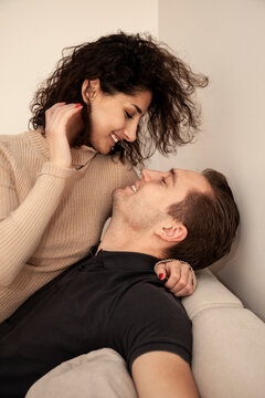 Smiling young couple embracing on sofa