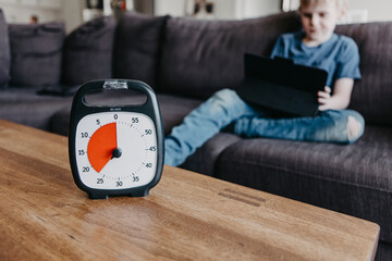Boy spending time with laptop according to clock