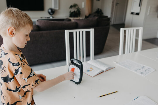 Schoolboy doing homework according to clock