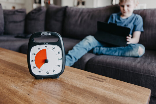 Boy spending time with laptop according to clock