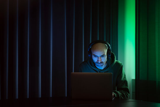 Man working on laptop in dark office
